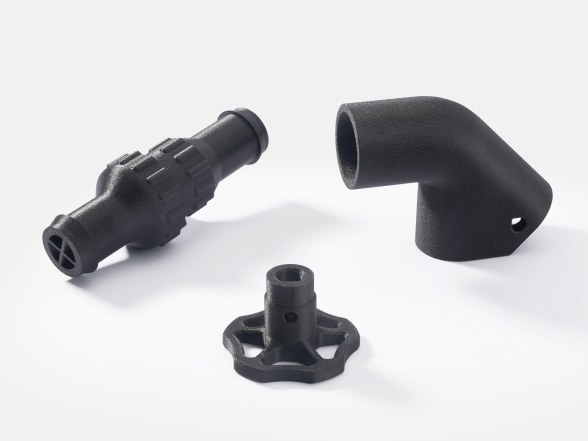 Three black PPS-CF parts on white: a pipe fitting, an elbow and a handwheel